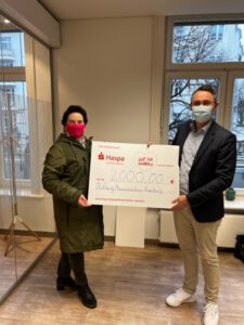 Stiftungsvorstand Angelika Grau nimmt eine Spendenzusage von € 2.000 aus dem Zweckertrag des Haspa LotterieSparens von Filialdirektor Viktor Kisinger in der Haspa-Filiale Klosterstern entgegen.